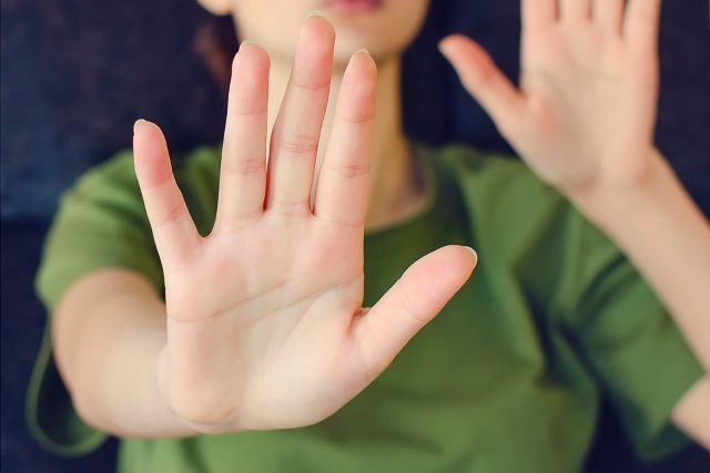 こちらに両手を向ける女性